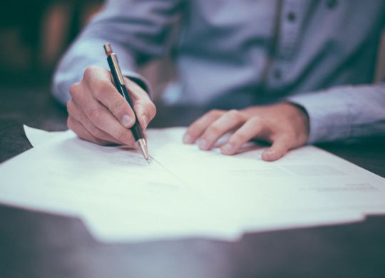 man-writing-at-desk